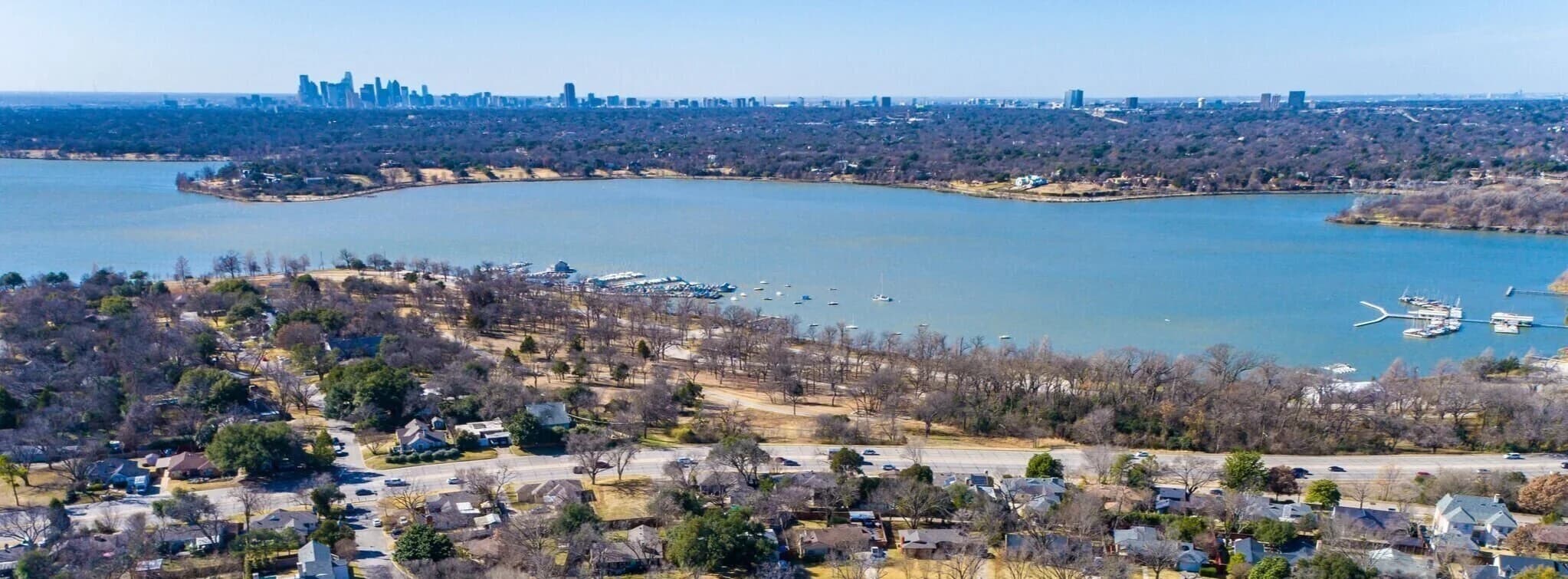 Aerial view of White Rock Lake with the downtown Dallas skyline behind, the Lake Highlands neighborhood we serve in north Dallas