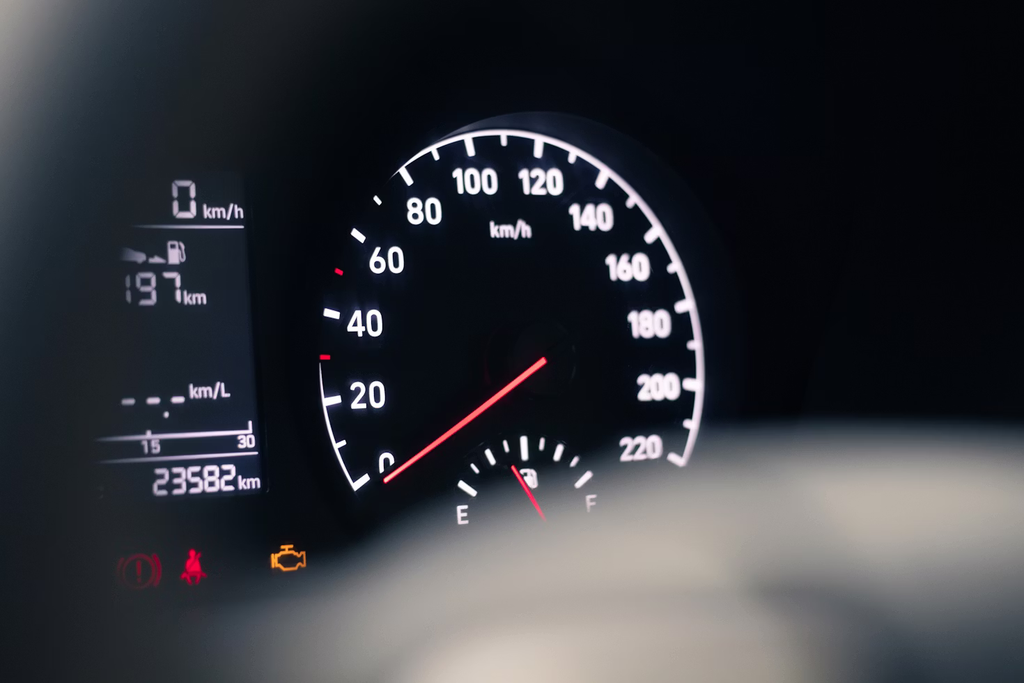 Illuminated check engine warning light glowing amber on a vehicle instrument cluster